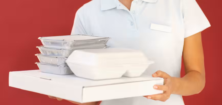 Front view portrait of delivery woman holding fast-food
