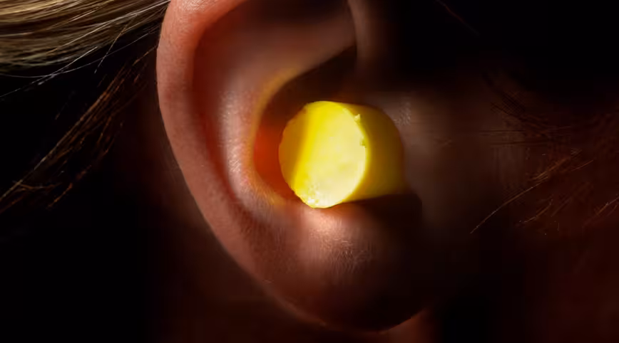 Woman Wearing Foam Earplug in Ear