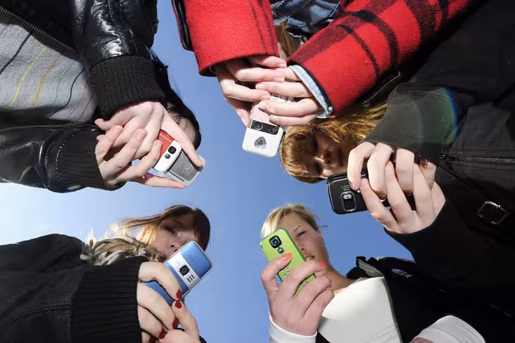 Teenagers use their mobile phones after