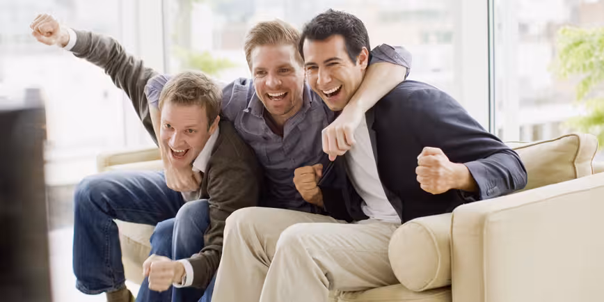Cheering friends watching television