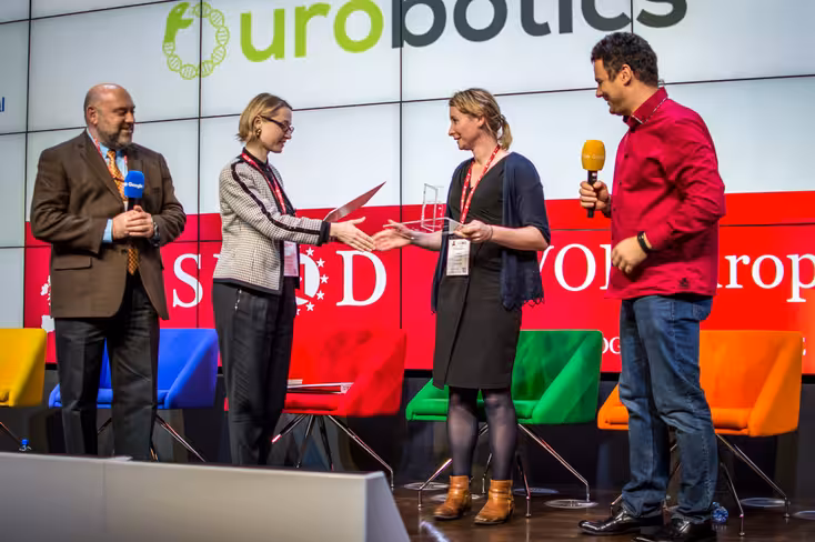 Anna Dvornikova, Managing Partner at TEC Ventures, passes the first prize to Jemma Redmond, CEO of Ourobotics