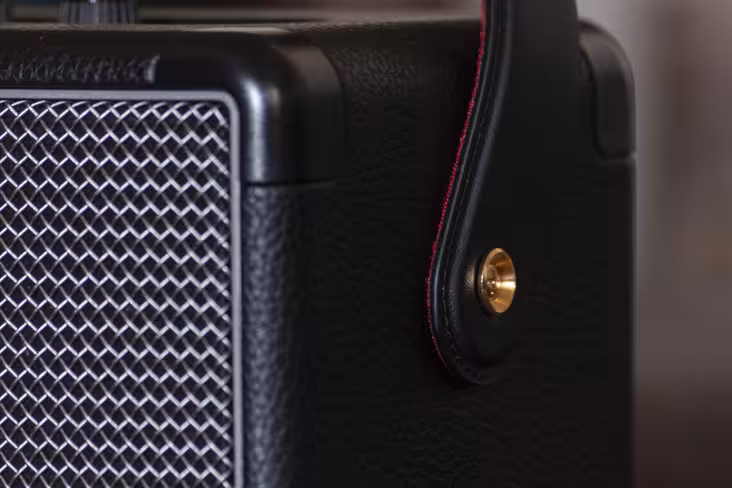 The strap and attachment button are reminiscent of guitar accessories