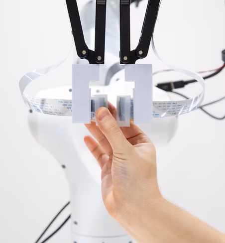 The system combines a neuromorphic brain with vision and touch data.