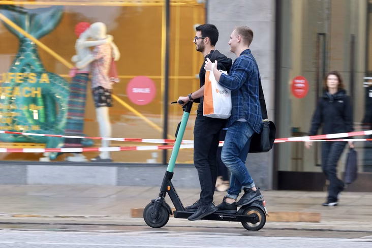 two people riding on the same scooter 