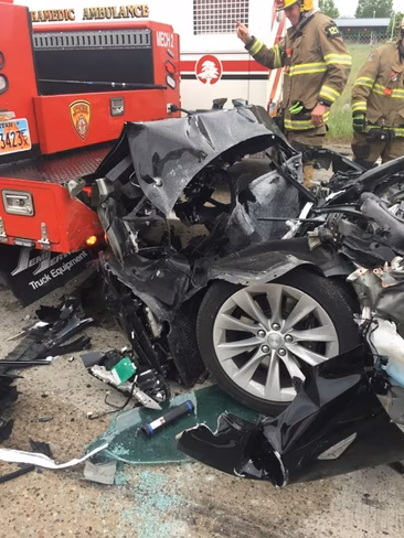 Crashed Tesla car with Fire Department assisting rescue