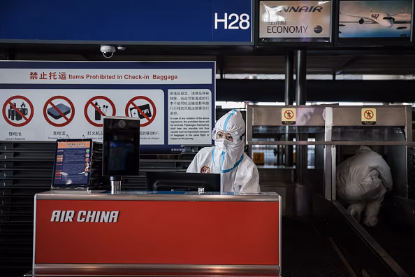 BEIJING, CHINA - FEBRUARY 21: An airport staff member in a hazmat suit works at the Beijing Capital International Airport on February 21, 2022 in Beijing, China. Officials, athletes, and media have started to leave Beijing after the closing ceremony of the Beijing 2022 Winter Olympics. (Photo by Annice Lyn/Getty Images)