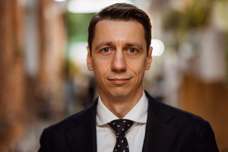 A photo of Denis Gursky wearing a suit