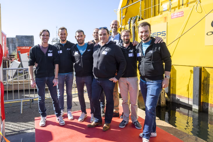 Lhyfe employees in front of electrolyser platform at inauguration 