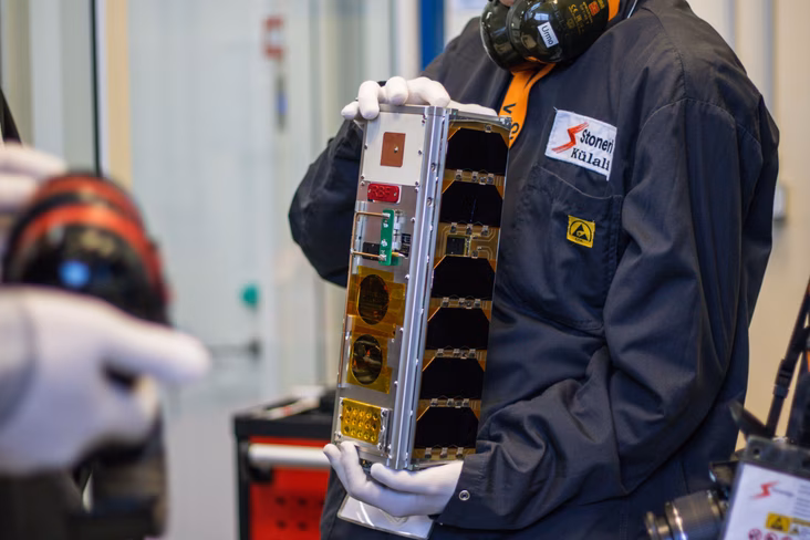A person holding the EST Cube-2 satellite