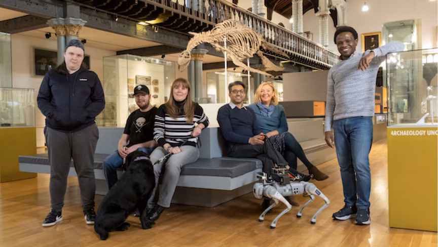 The RoboGuide team at the Hunterian museum with a living guide dog and the robotic guide dog