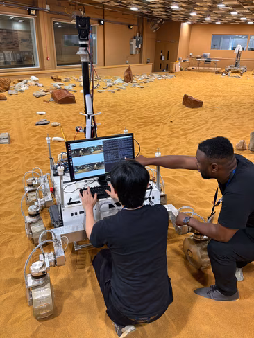 Two men using a laptop attached to a Mars space powered by natural intelligence