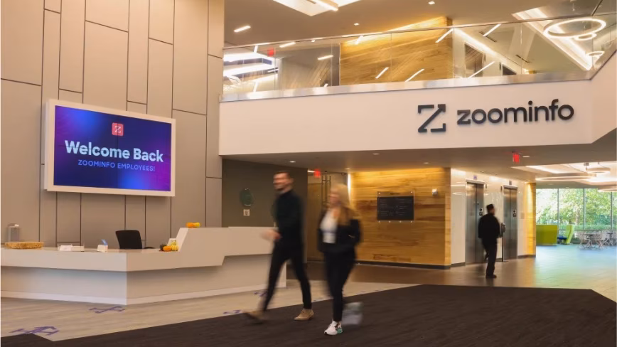 ZoomInfo beat earnings, cut 600 jobs, and lost 29 per cent of its stock price. Its database is being repriced by AI.