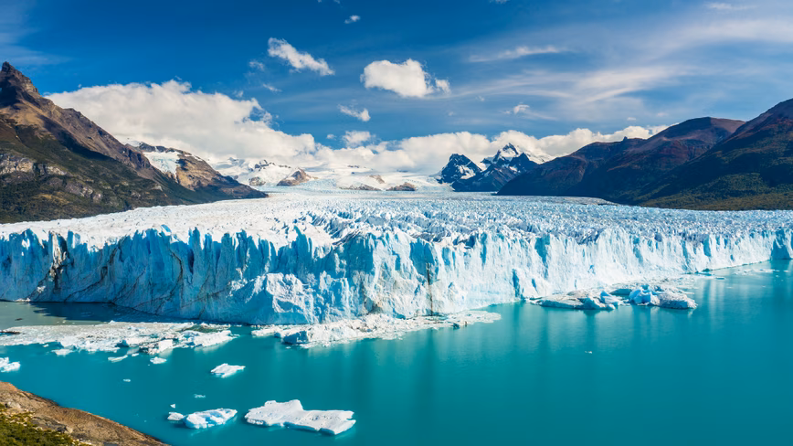 The Perito Moreno Glacier meeting turquoise water in Los Glaciares National Park, Argentina, with mountains behind