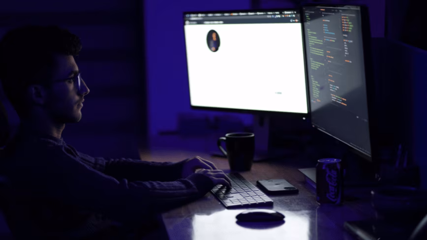 Developer working at night on dual monitors