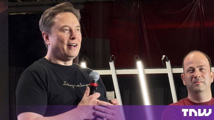 https://media.thenextweb.com/2026/09/elon-musk-onstage-microphone-tesla-fremont.jpg