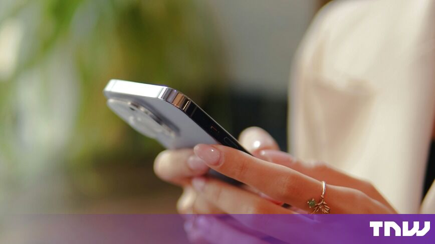 https://media.thenextweb.com/2026/09/hand-holding-lilac-smartphone-gold-leaf-ring-blurred-plant.jpg