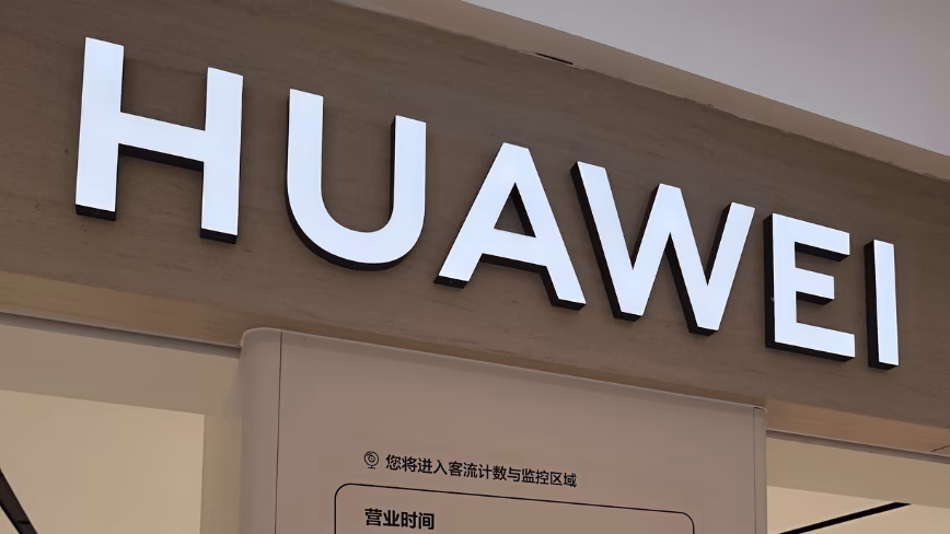 The Huawei logo in red and white on illuminated signage above the entrance to a retail store in a shopping mall