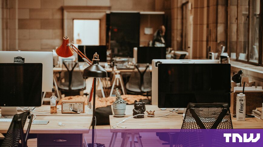 https://media.thenextweb.com/2026/09/open-plan-office-empty-desks-monitors.jpg