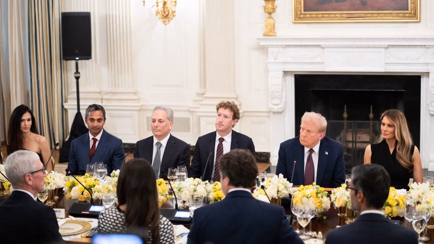 Donald Trump seated at a long dinner table in the White House State Dining Room beside Mark Zuckerberg and Melania Trump, with other guests around the table.