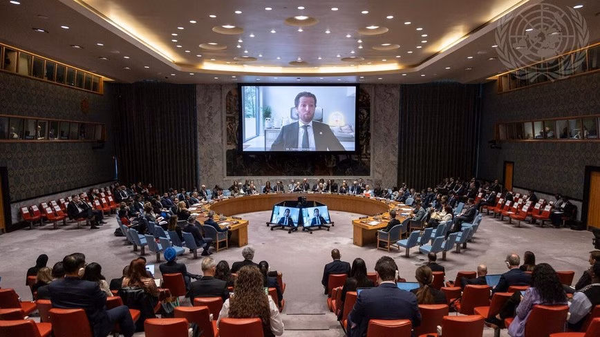Clément Delangue appears on a large video screen above the UN Security Council chamber, with delegates and observers seated below.