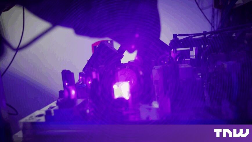 https://media.thenextweb.com/2026/10/atom-computing-neutral-atom-quantum-laser-optics-violet.jpg